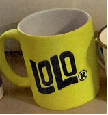 A yellow coffee mug with a handle, with "LOLO®" printed prominently in black on the side. 